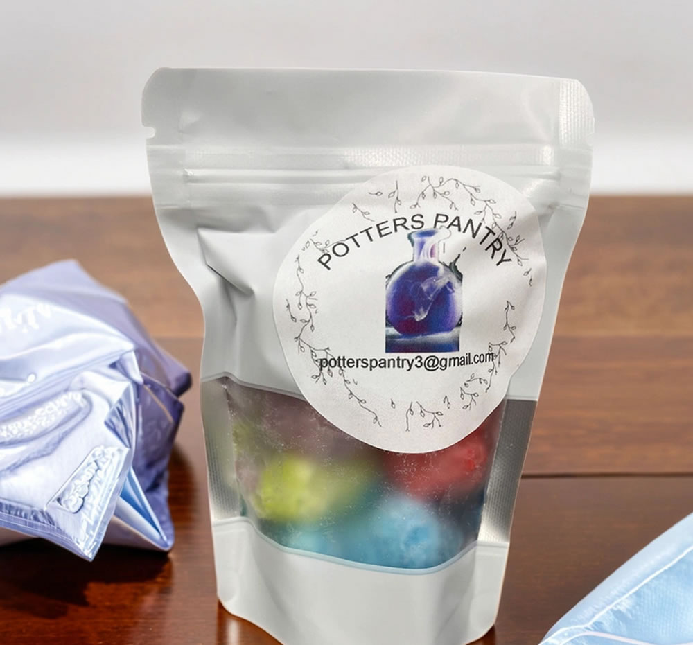 A resealable semi-transparent bag labeled "Potters Pantry - Freeze Dried Gummy Bears" with colorful contents inside is placed on a wooden surface next to a white cloth.