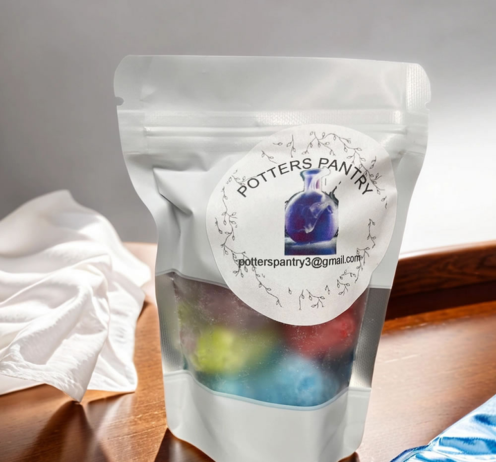 A resealable semi-transparent bag labeled "Potters Pantry - Freeze Dried Gummy Bears" with colorful contents inside is placed on a wooden surface next to a white cloth.