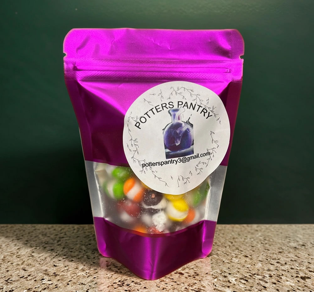 A purple plastic pouch labeled "Potters Pantry" containing colorful candy, displayed on a granite countertop.